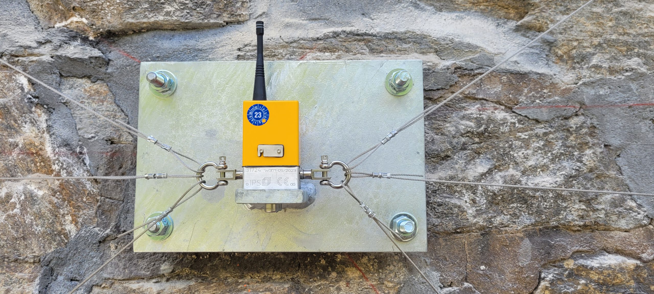 Impact Sentinel sensor mounted on stone tunnel wall measuring vibration and structural movement on the Gotthard railway line